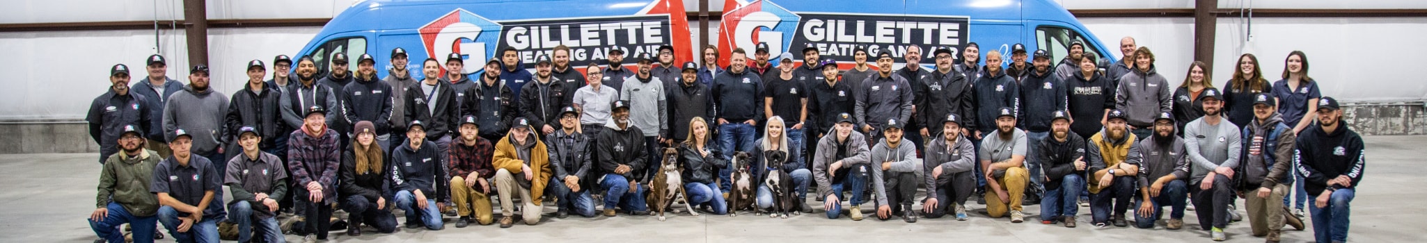 Gillette Team image, all of the technicians and crew standing in front office building and service vans.