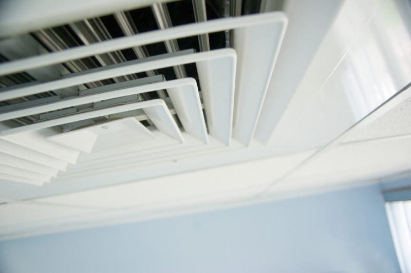 How Sealing Your Air Ducts Can Save You Money - air condition vent in office ceiling close up.